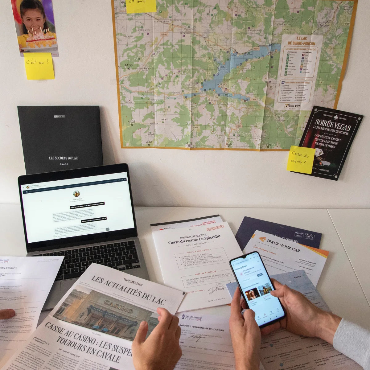 Deux enquêteurs Deep Detective analysent les indices du casse du casino autour du lac de Serre-Ponçon, entre articles, carte et plateforme interactive d’enquête à la maison.